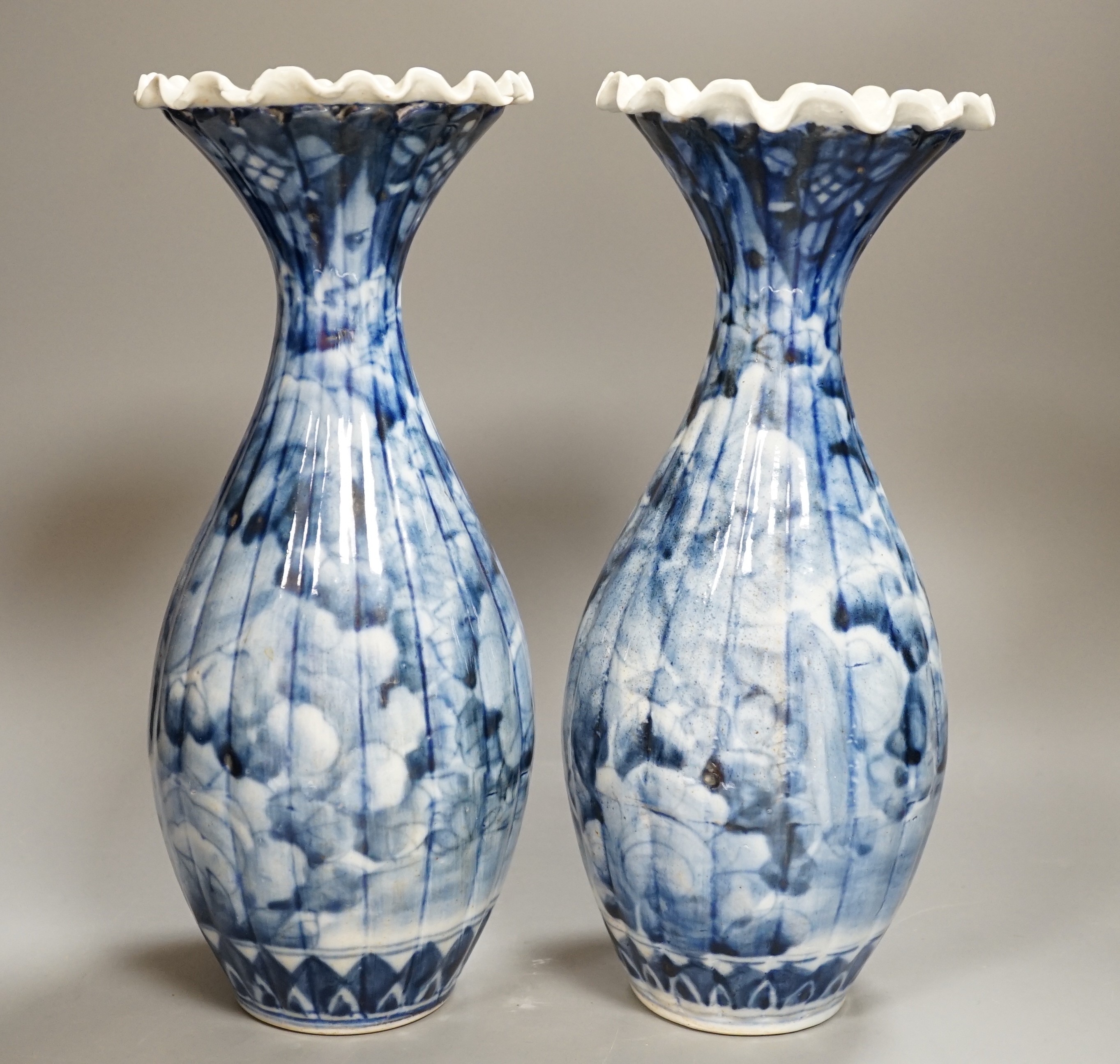 A pair of early 20th century Japanese fluted blue and white flared rim vases, 31.5cm